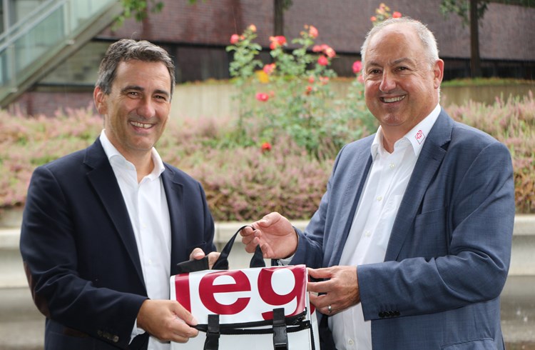 Urs Styger (rechts) übergibt dem neuen Direktor Laurent Prince (links) einen prall gefüllten Rucksack von Rollstuhlsport Schweiz. (Foto zvg)
