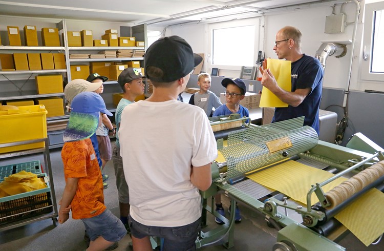Fritz Richli zeigt den Kindern des Ferienspasses Neuenkirch, wie er Bienenwachs zu Kunstwaben verarbeitet. (Foto wy)