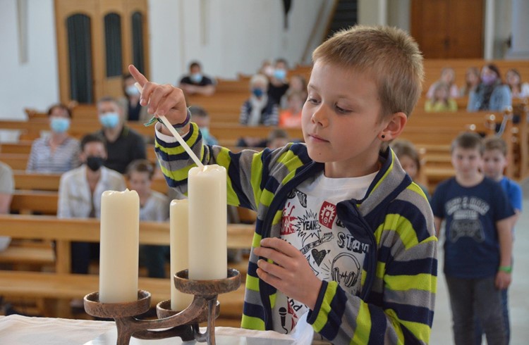 Elias Gut zündet die Kerzen auf dem geschmückten und für das Mahl vorbereiteten Altar an. (Foto Margrit Leisibach-Hausheer)