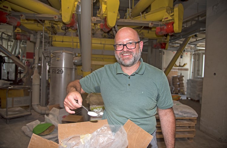 Stephan Roth leitet die Forschung und Entwicklung der UFA. Auf dem Löffel zeigt er die Mischung Agolin Ruminant, welche die Verdauung der Milchkühe verbessert und so die Methanemmissionen bis zu 20 Prozent reduziert.  (Foto Thomas Stillhart)