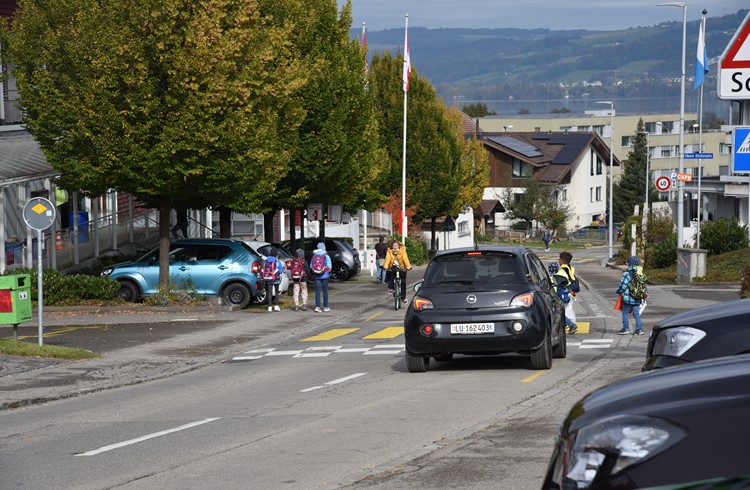 Schüler überqueren die Oberdorfstrasse beim Zentrum Sagi. Links sind die rechtwinklig zur Fahrbahn angeordneten Parkplätze zu sehen. (Foto Geri Wyss)