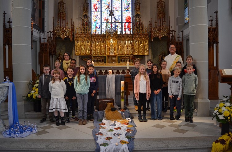Die Schar der Erstkommunionkinder mit der Katechetin Regula Soom und Pfarreileiter Erich Hausheer (Foto Emil Barmet)