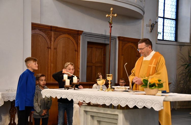 Die Kinder decken den Altar und zünden Kerzen für den Frieden an, bevor Priester Thomas Sidler mit allen  die Eucharistie feiert.  (Foto Margrit Leisibach Hausheer)