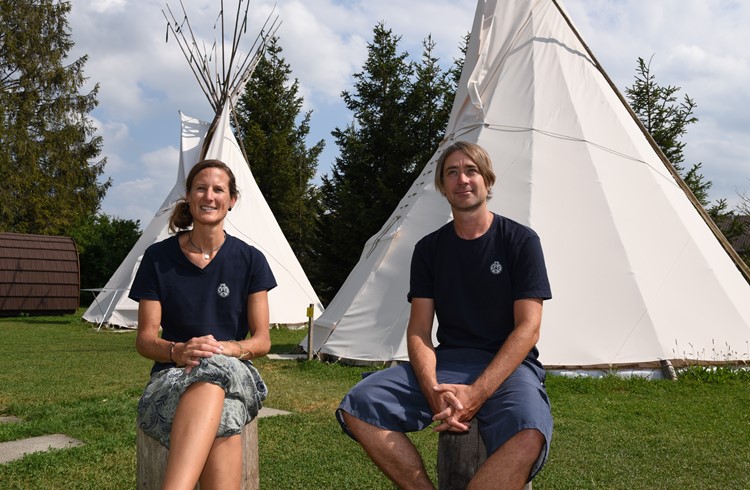 Martina Wazzau und Elias Torgler sitzen im «Glamping»-Bereich mit den Pods und Tipis des TCS-Campings Seeland, den sie seit dem 1. Juni 2021 führen. (Foto Julian Wismer)