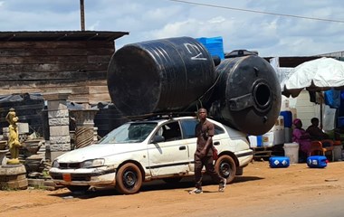 In der Schweiz würde ein solches Fahrzeug auf den Strassen für einen Aufschrei sorgen. In Kamerun ist dieses mit Wassertanks beladene, lädierte Auto keine Ausnahme. | Balz Koller